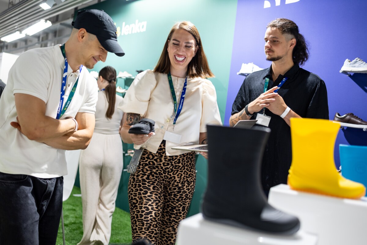 Visitors and an exhibitor chatting beside a boot display, photo by Messe Offenbach / Esra Klein